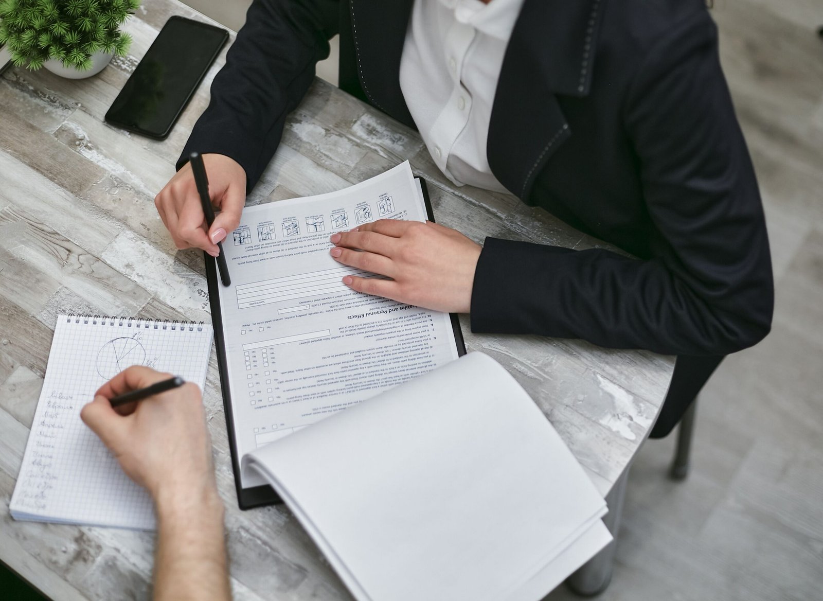 Two people comparing documents at a desk, representing the comparison between a commercial lease and a licence