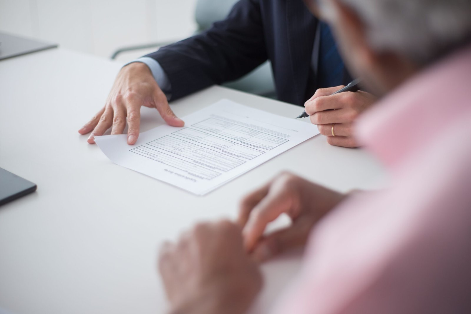 Two professionals shaking hands over a signed agreement, representing an exclusivity clause in a supplier contract