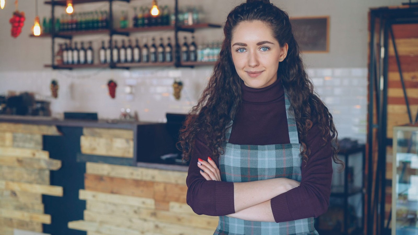UK small business owner standing confidently in their shop, representing cash flow management for small business owners