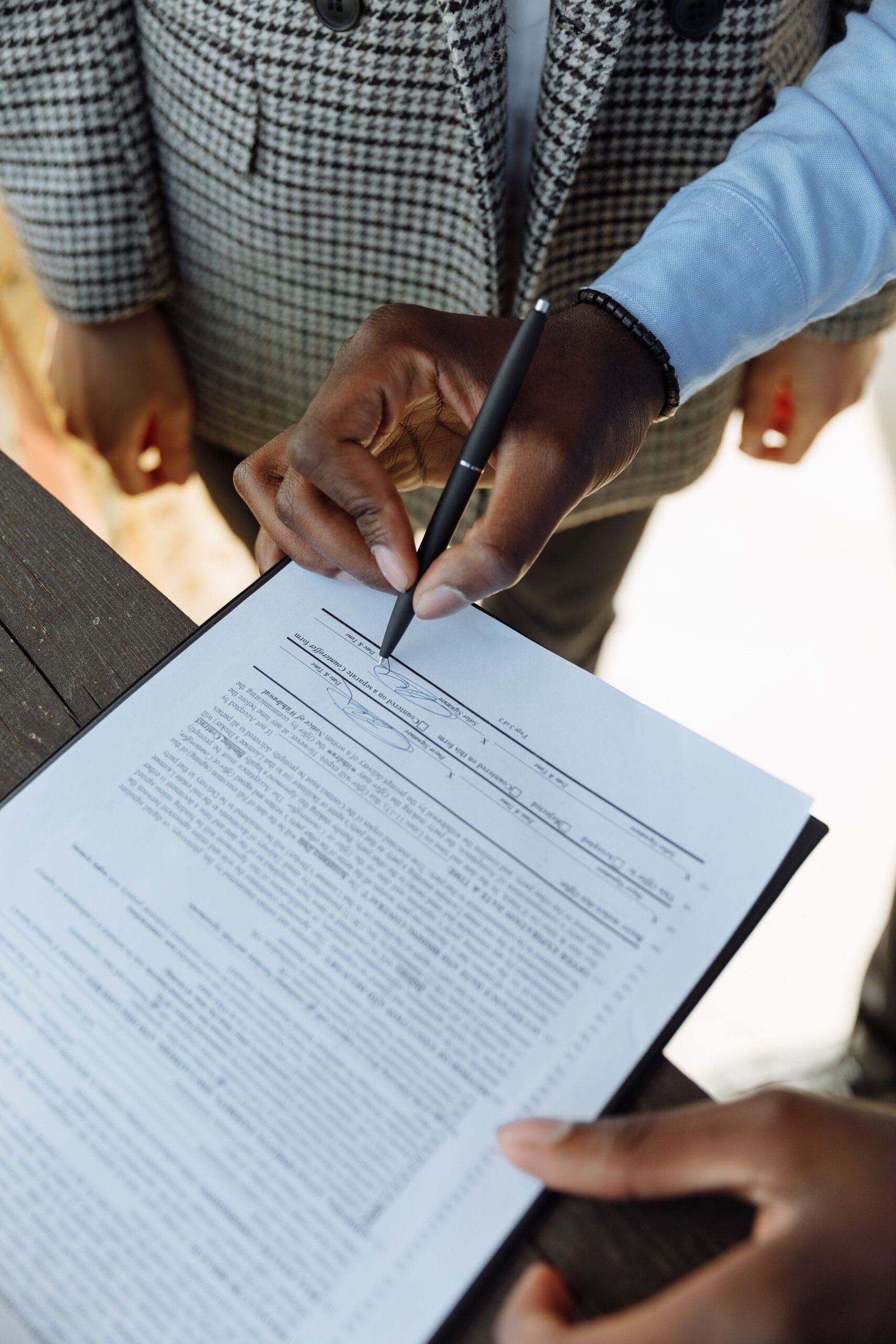 Person signing a commercial lease contract with a pen, representing negotiating a lease for a small business