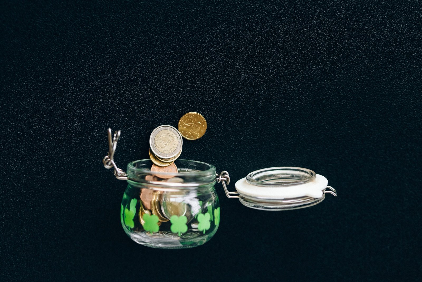 Coins in a glass savings jar on a wooden table, representing personal finance and budgeting