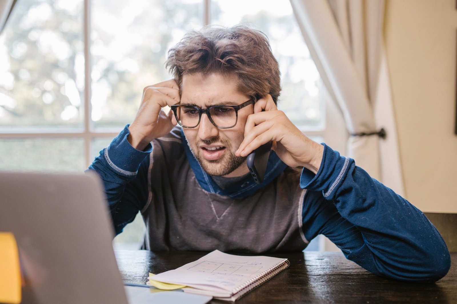 Man looking frustrated while using a laptop, representing dealing with a supplier contract breach