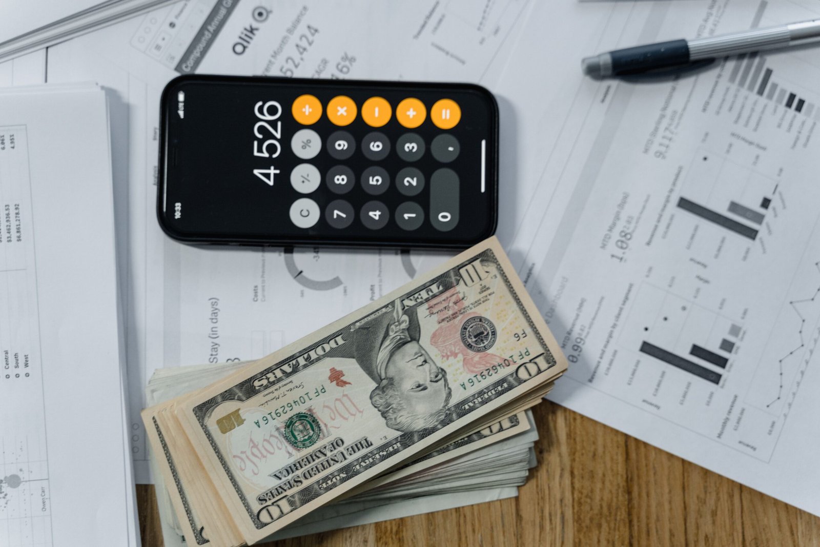 Cash, calculator and financial documents on a desk representing working capital for a small business